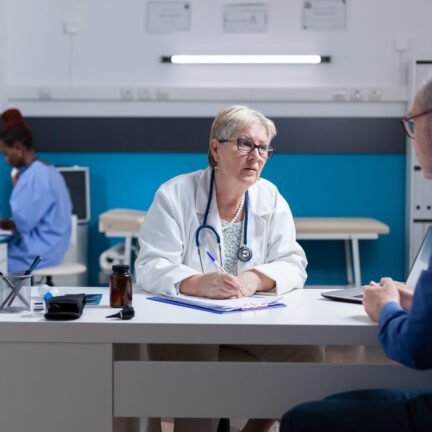 Medic doing signature on checkup papers to give prescription medicine to patient. Woman doctor signing documents after healthcare consultation, giving treatment to senior man with disease.